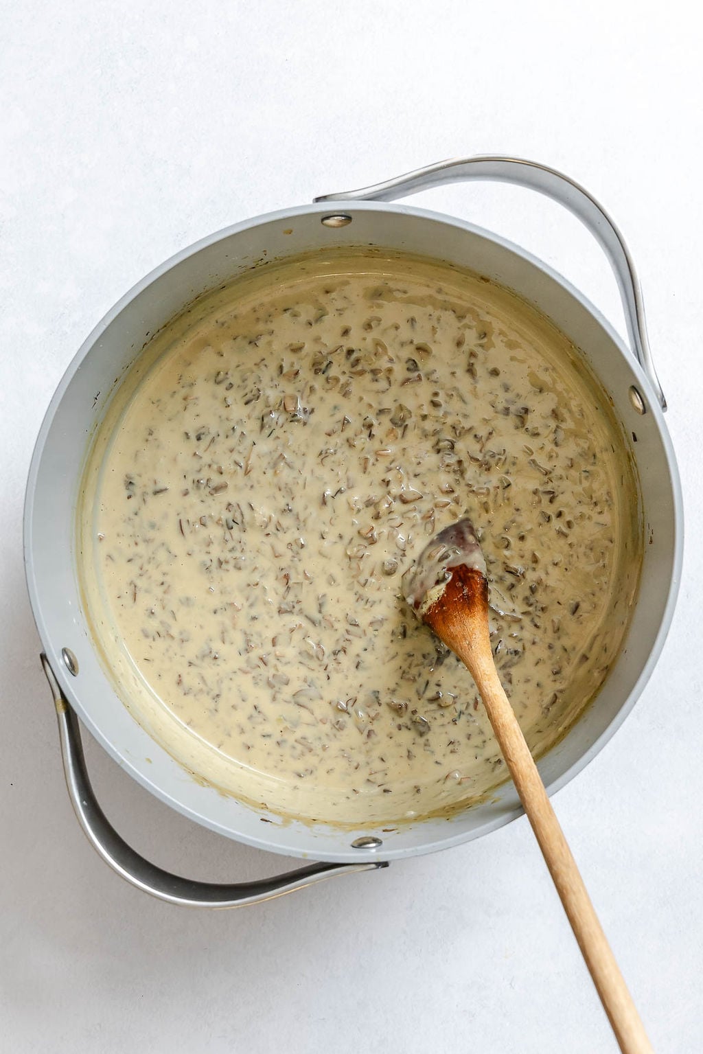 Process shot showing stirring ingredients in a pot.