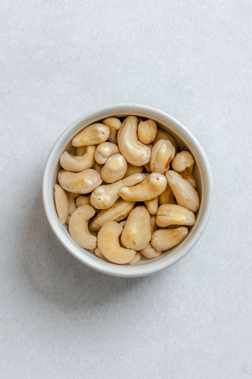 Process shot showing cashews in a bowl.
