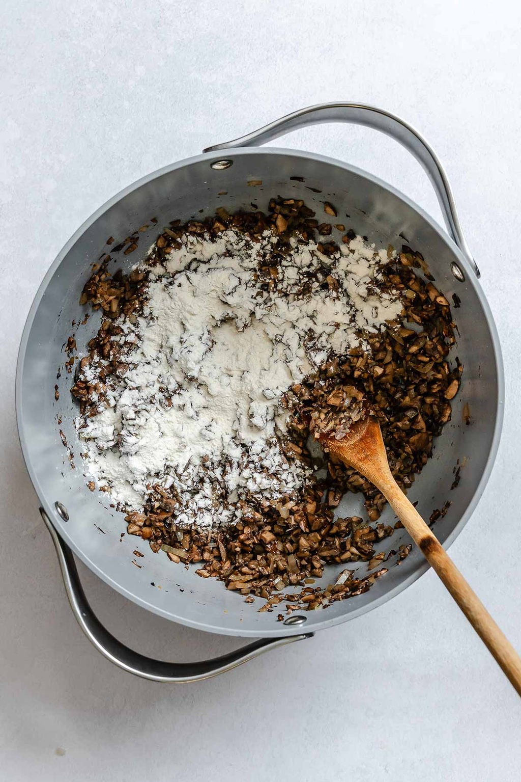 Process shot showing stirring ingredients in a pot.