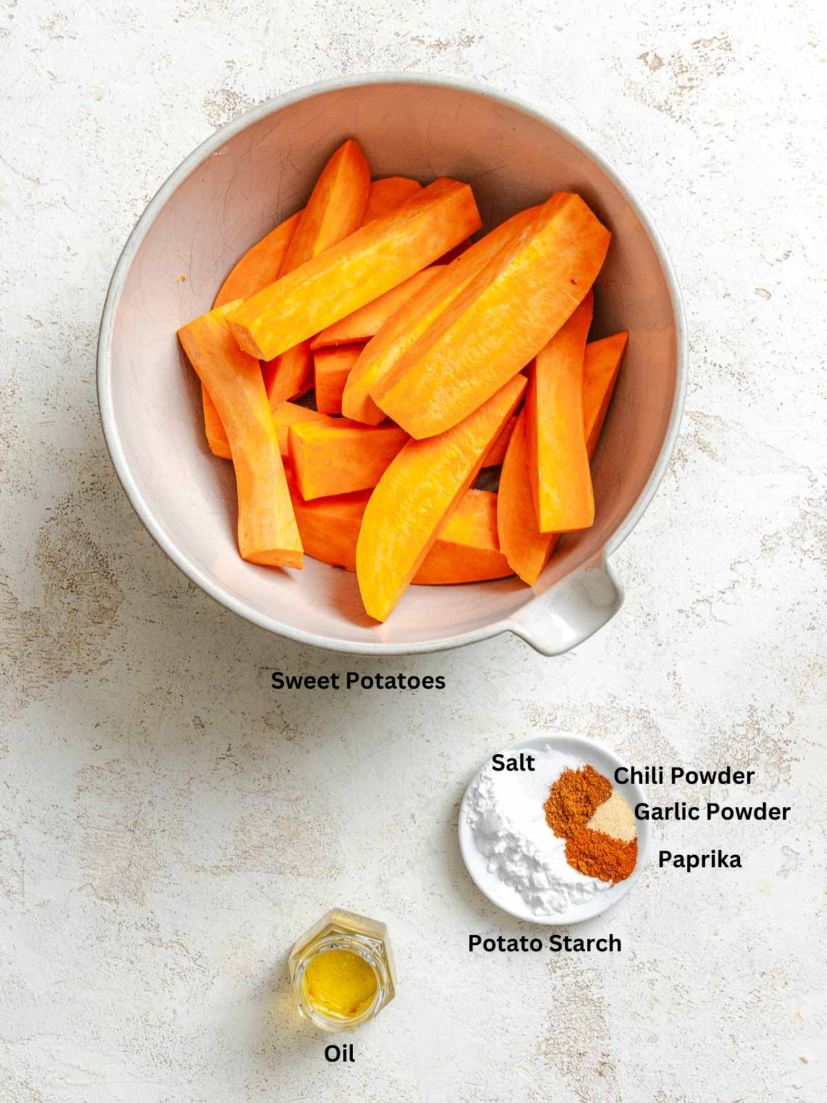 Ingredients for Air fryer Sweet Potato Wedges measured out on a white surface.
