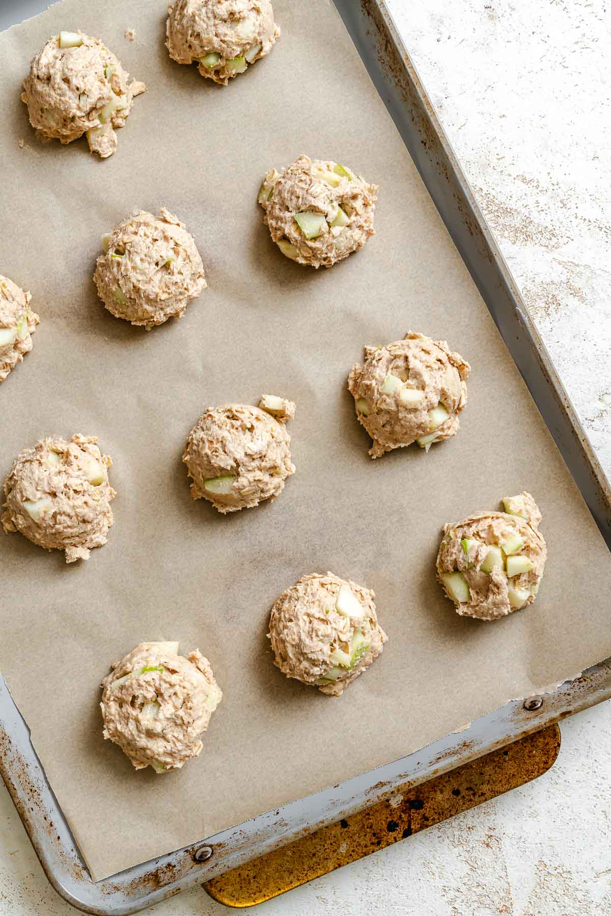 Process shot showing cookies added to baking tray.