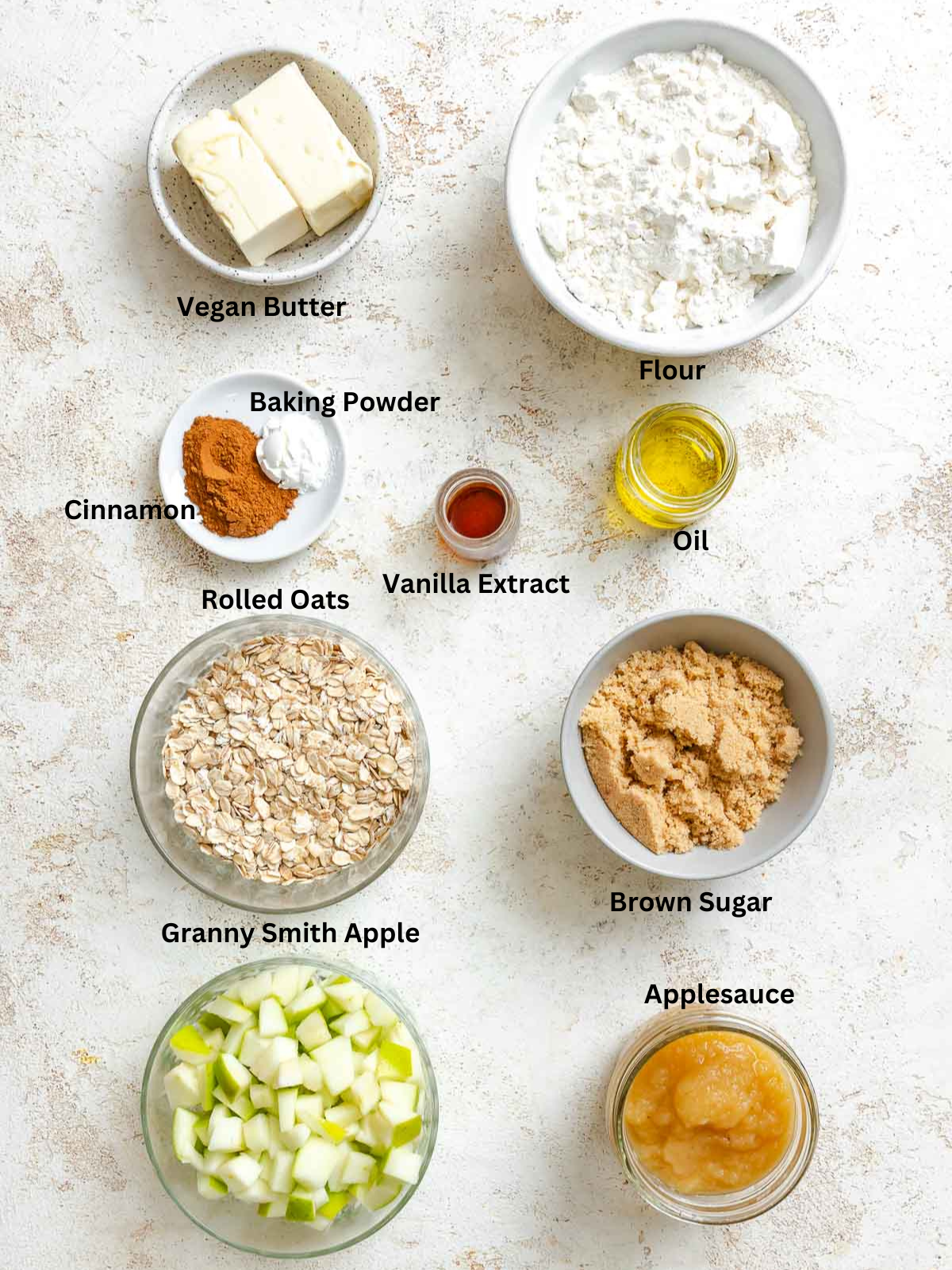 Ingredients for Apple Oatmeal Cookies measured out on a white surface.