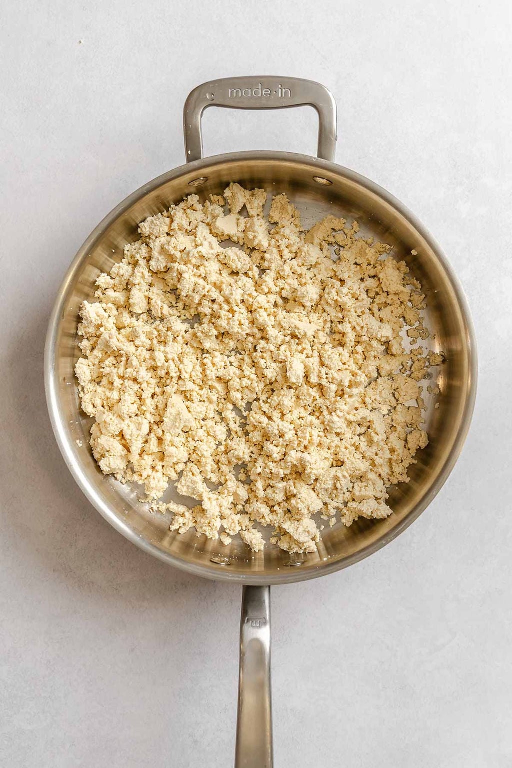 Process shot showing tofu cooking in a pan.
