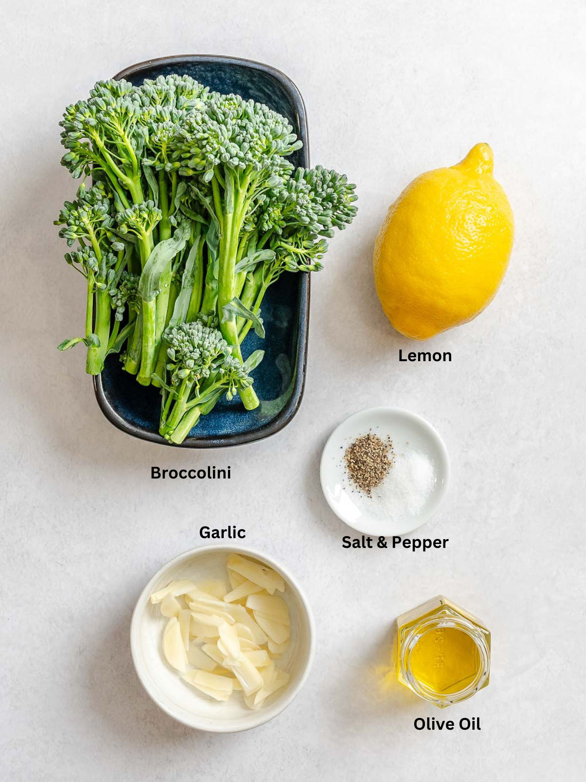 Ingredients for Sautéed Broccolini measured out on a white surface.
