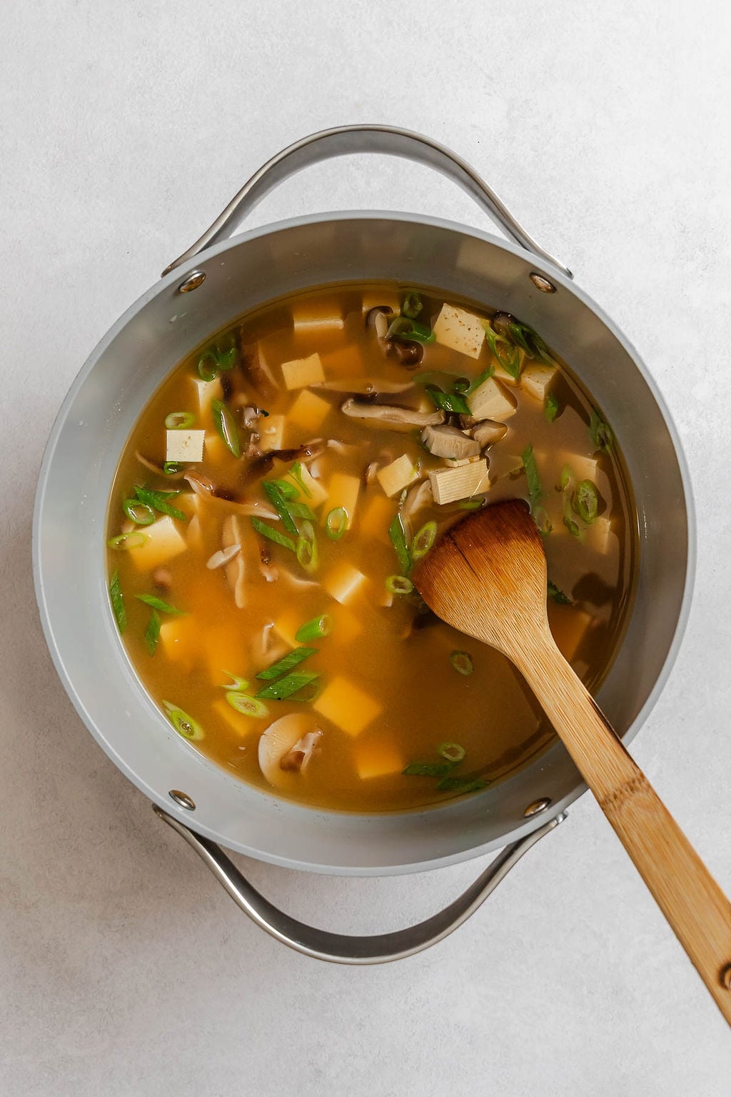 Process shot showing stirring ingredients in a pot.