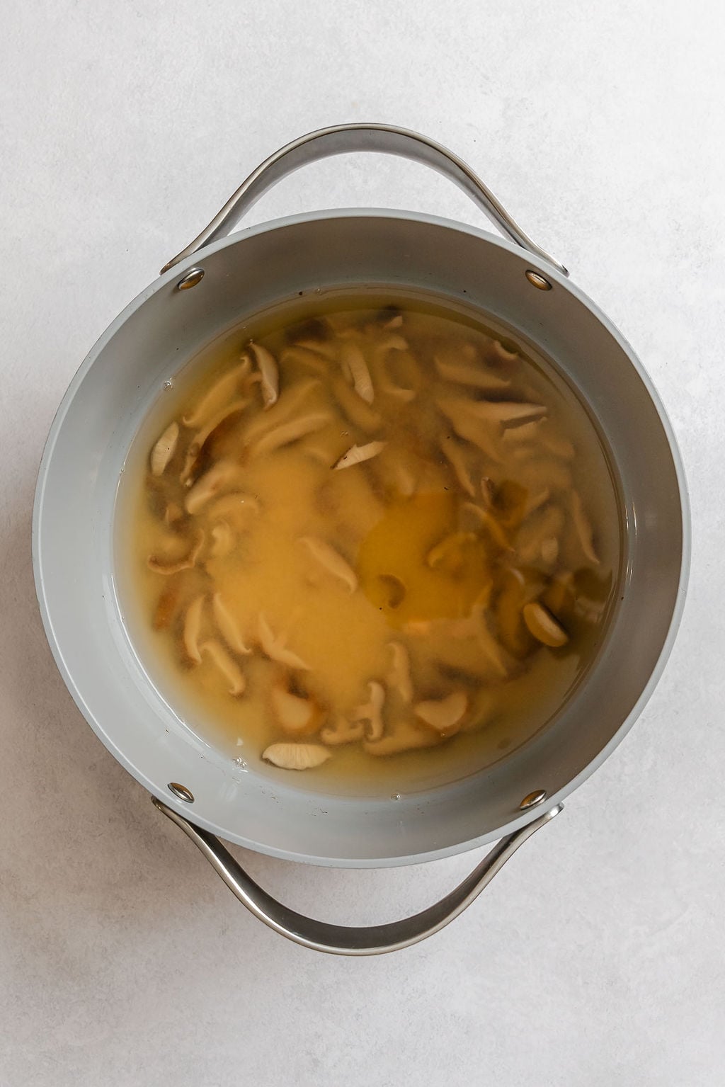Process shot showing ingredients cooking in pot.