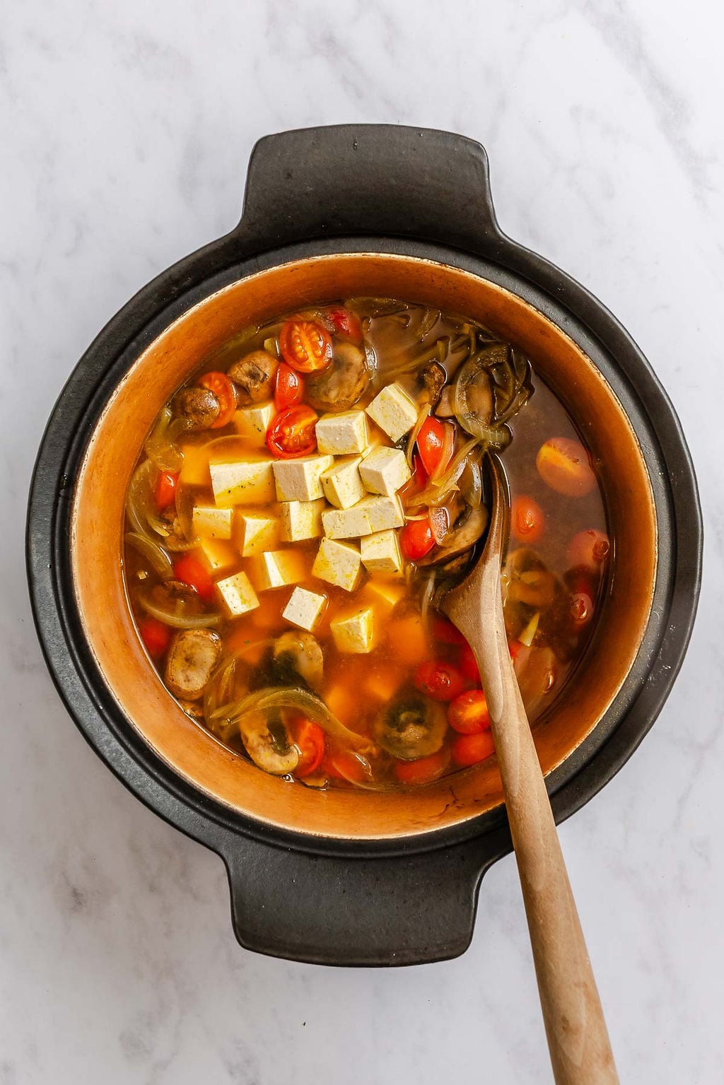 Process shot showing cooking Vegan Tom Yum Soup in a pot.
