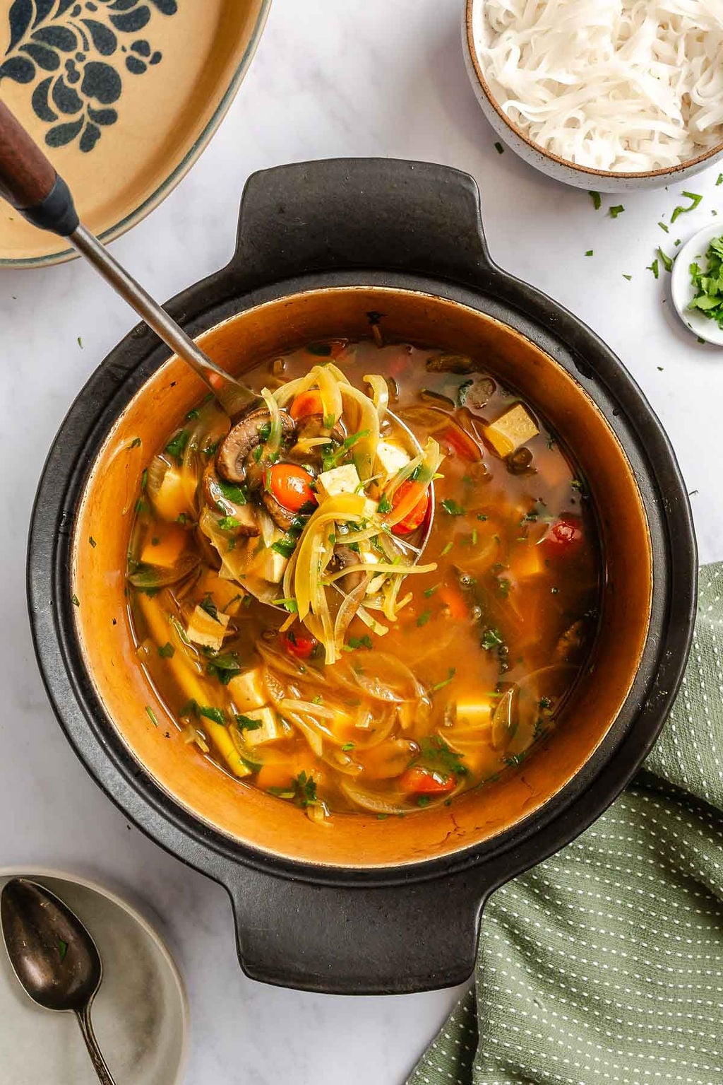 Process shot showing cooking Vegan Tom Yum Soup in a pot.