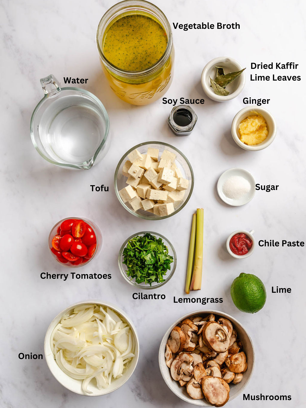Ingredients for Vegan Tom Yum Soup measured out on a white surface.