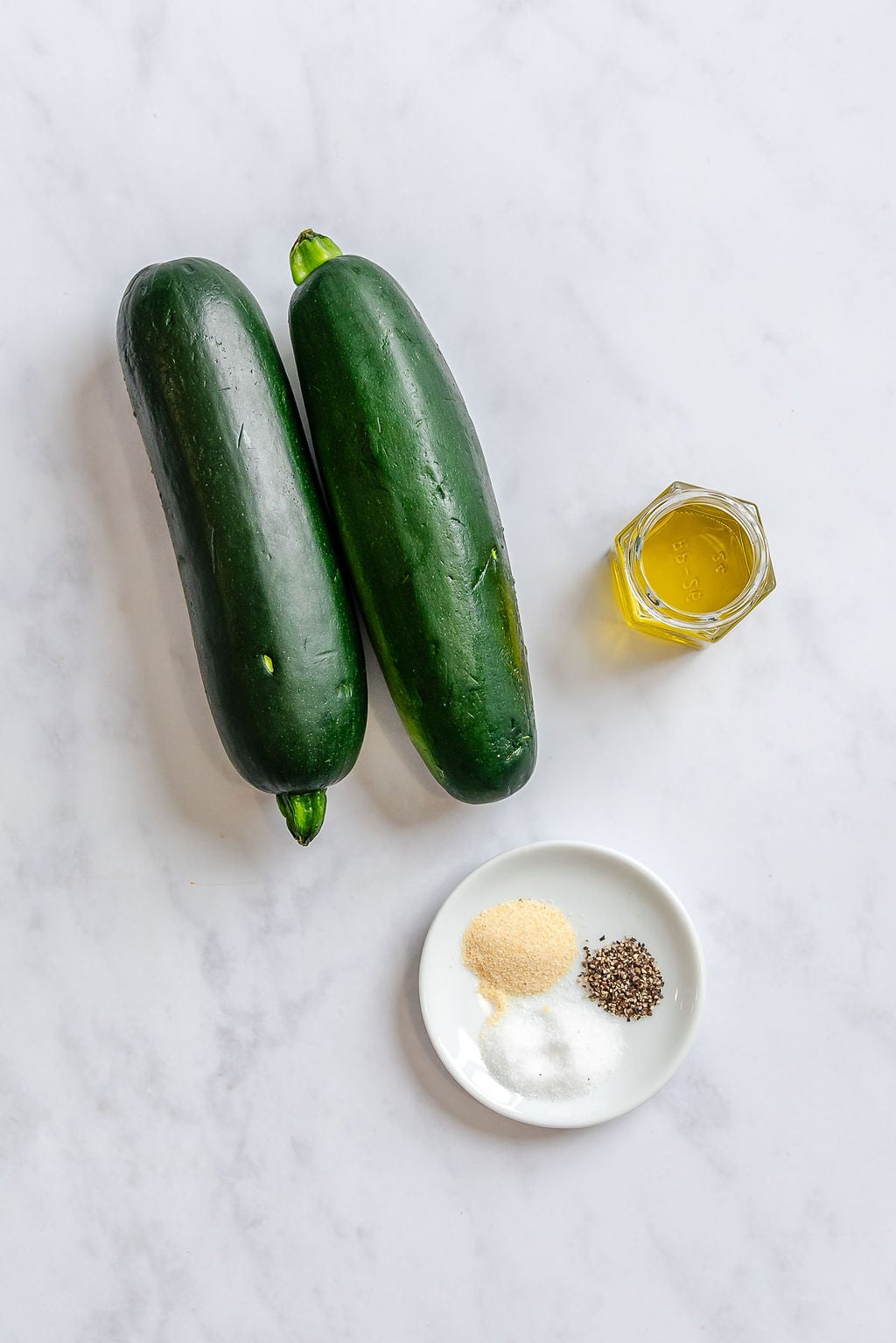 Ingredients for Quick Air Fryer Zucchini measured out on a white surface.