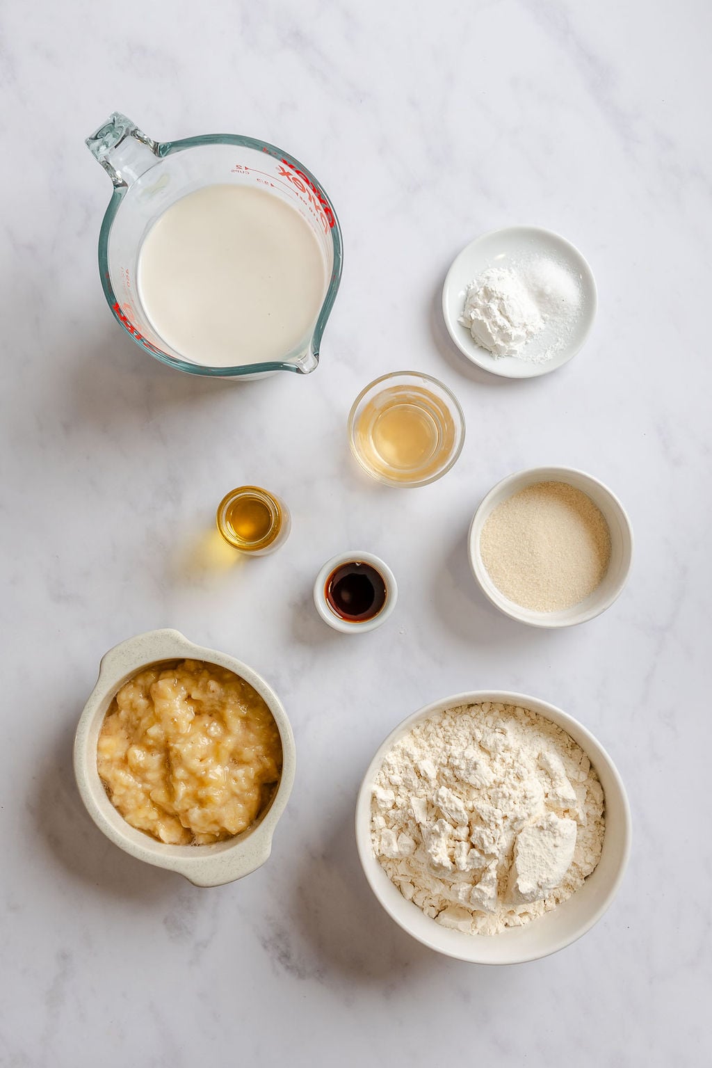 Ingredients for Easy Vegan Banana Waffles measured out on a white surface.