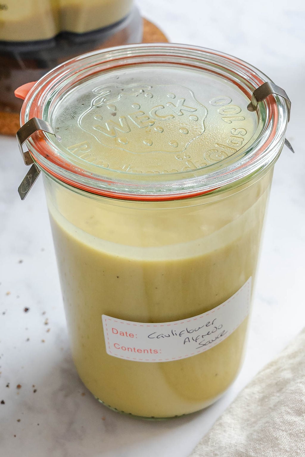 Completed Healthy Cauliflower Alfredo Sauce in a storage container.