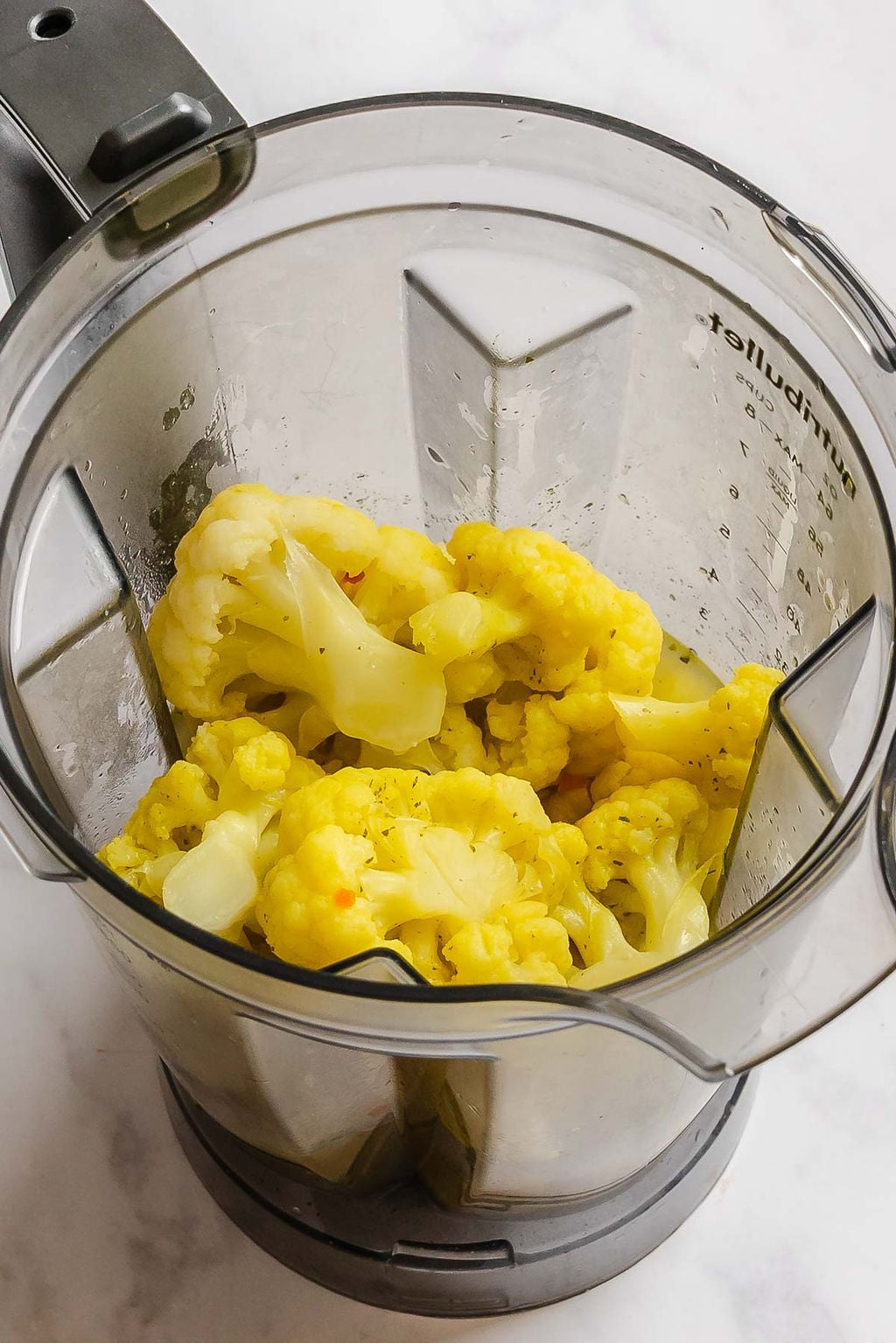 Process shot showing cauliflower in a blender.