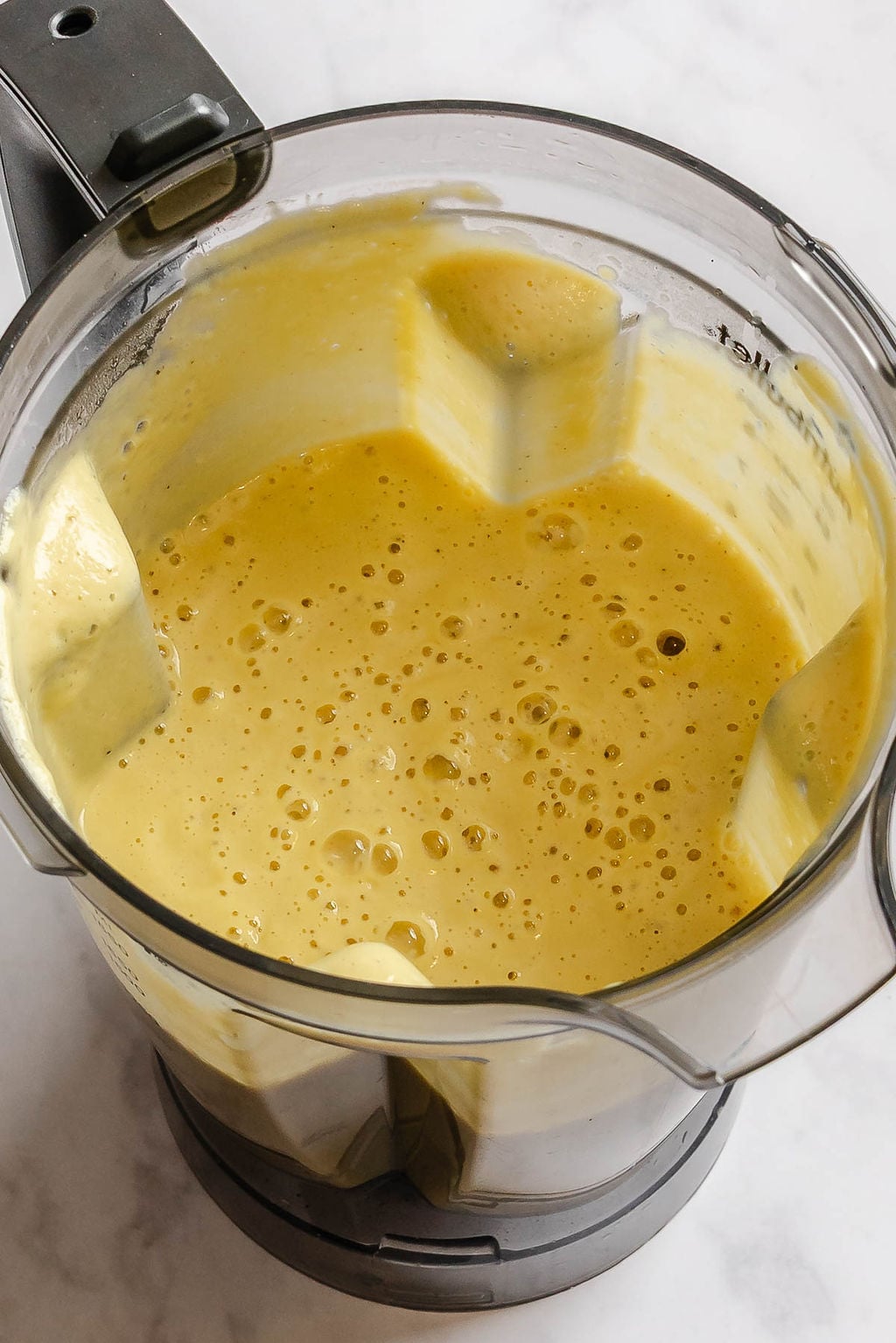 Process shot showing cauliflower blended in a blender.
