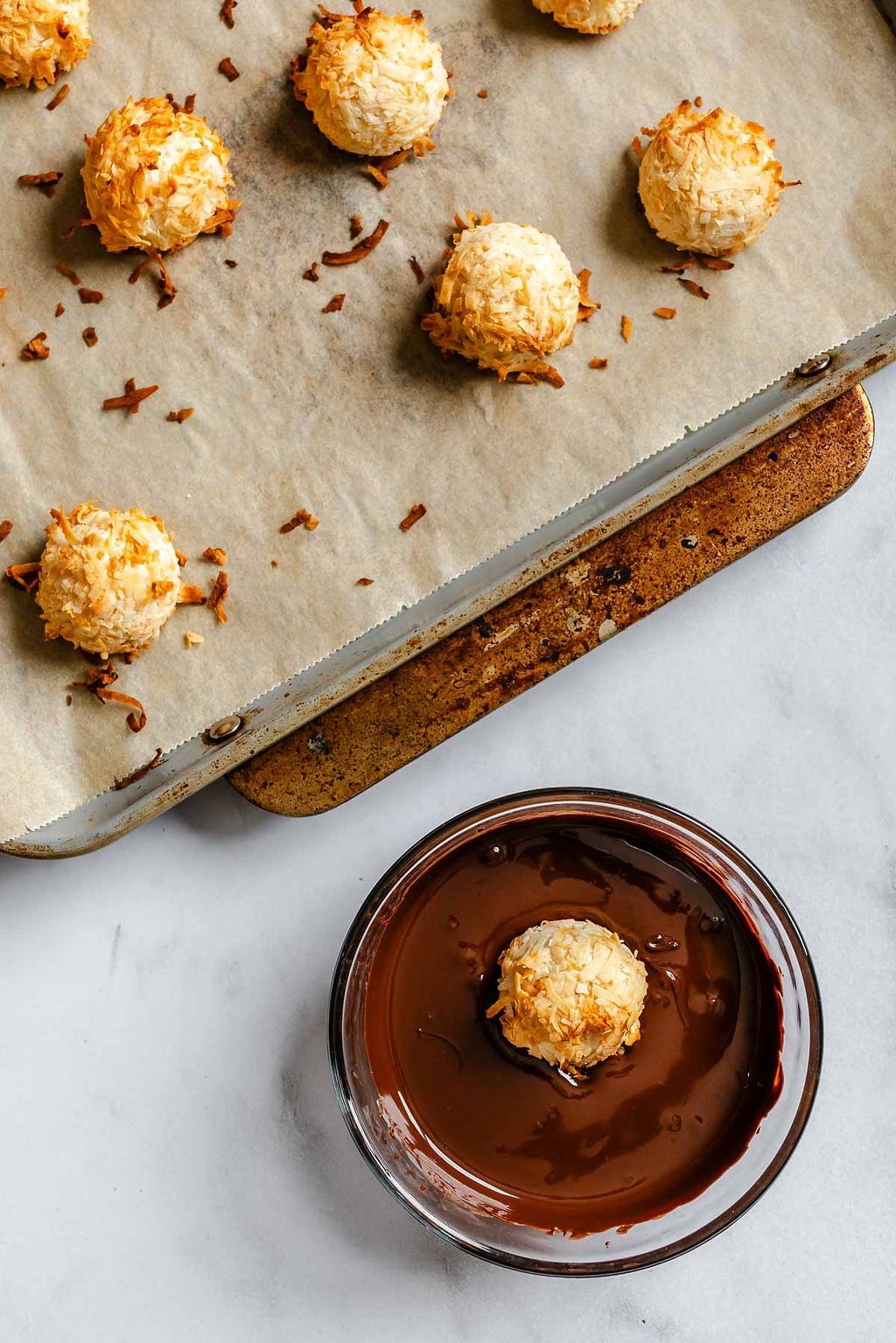 Process shot showing dipping macaroon in vegan chocolate.