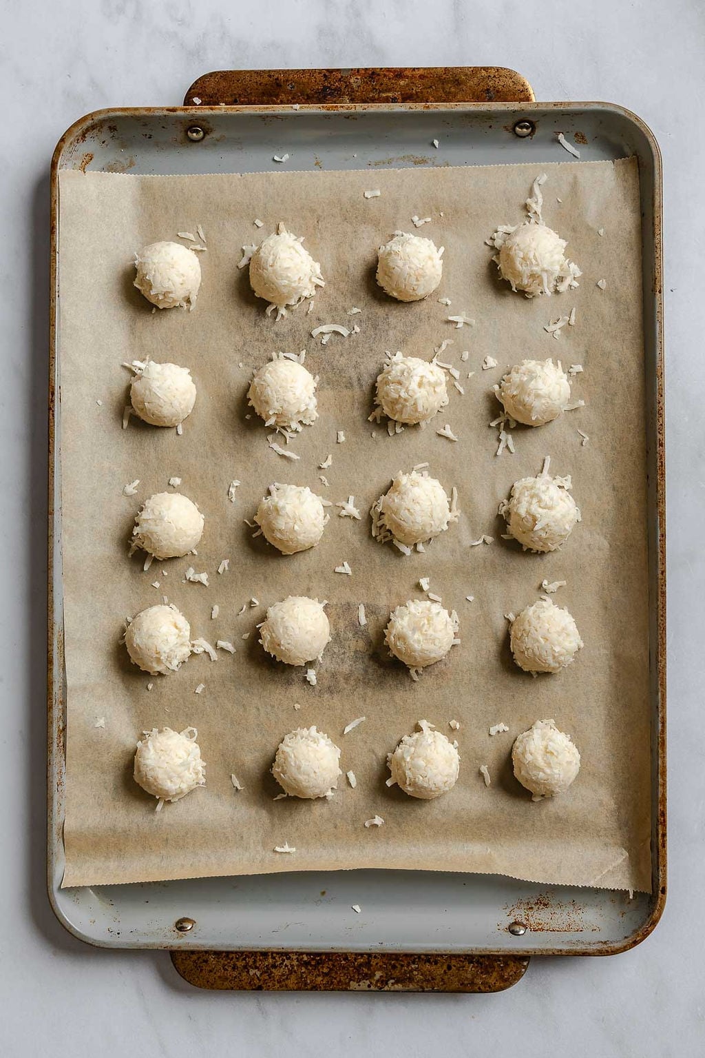 Process shot showing Vegan Coconut Macaroons on a baking sheet.