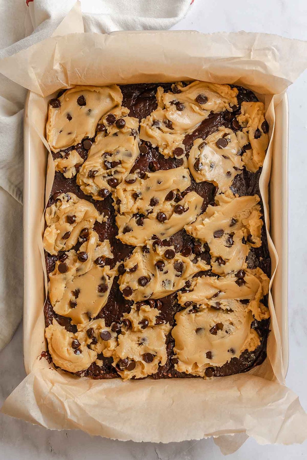 Process shot showing cookie dough added to baking dish.