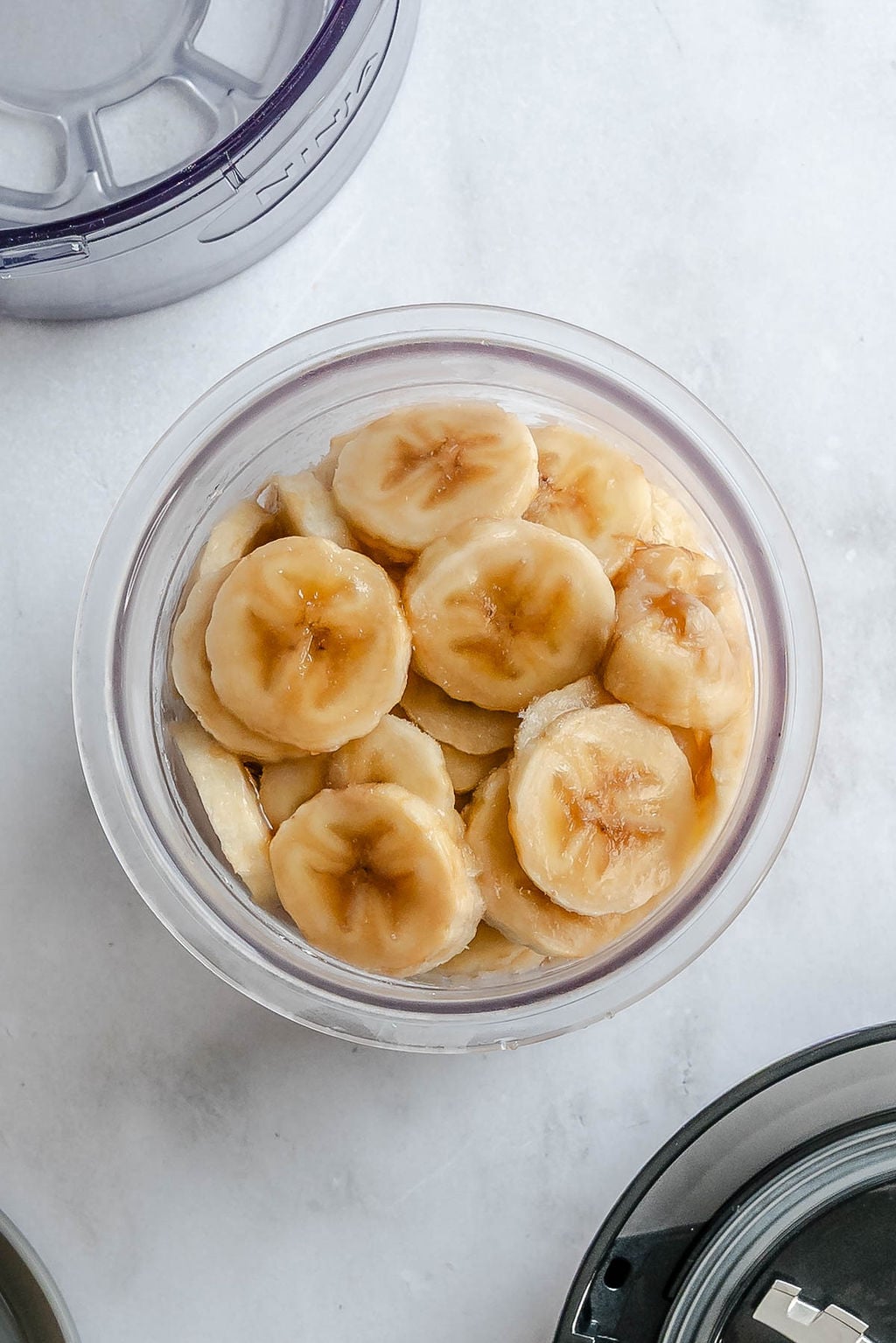 Process shot showing bananas added to jar.