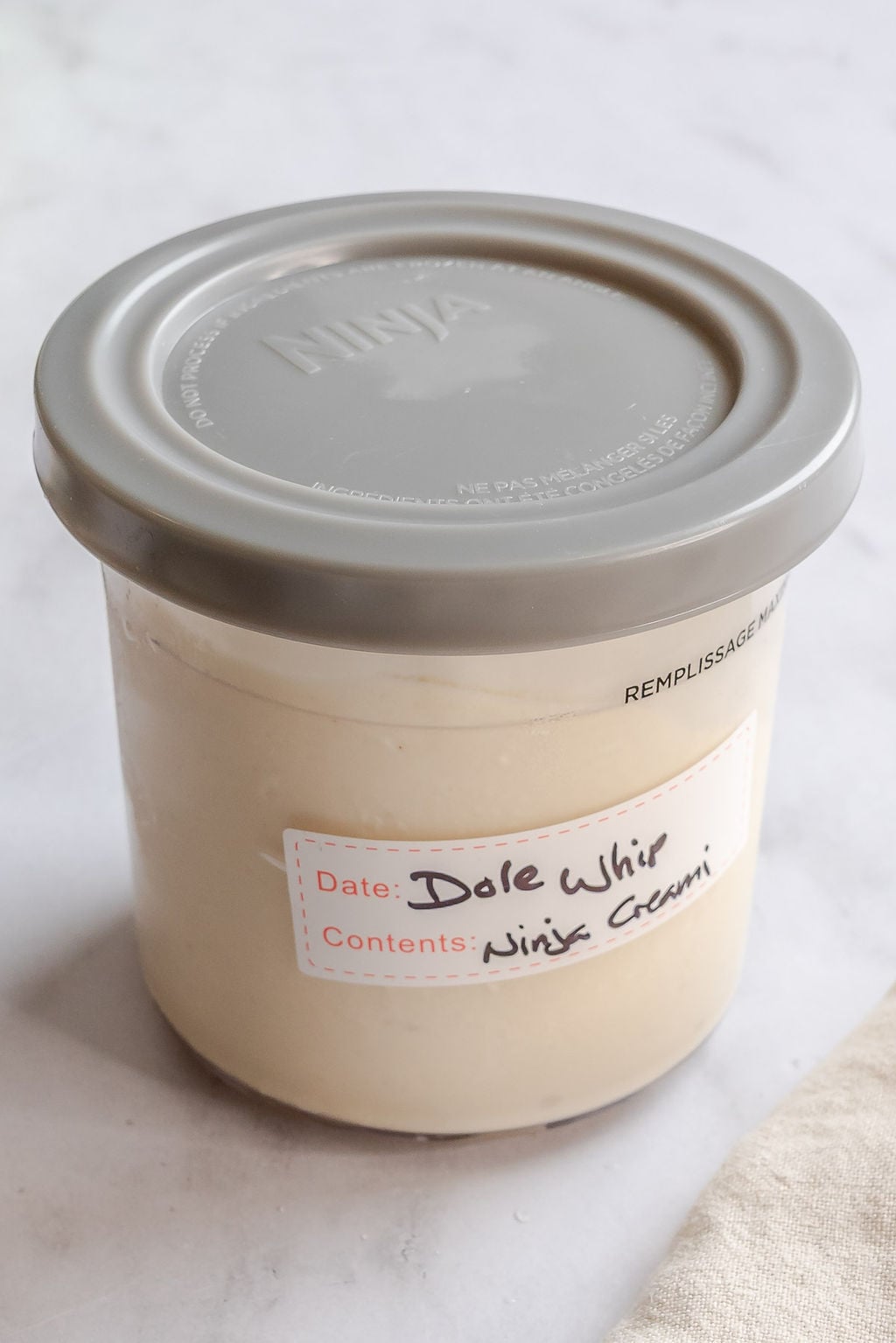 Completed Ninja Creami Dole Whip in a storage container.