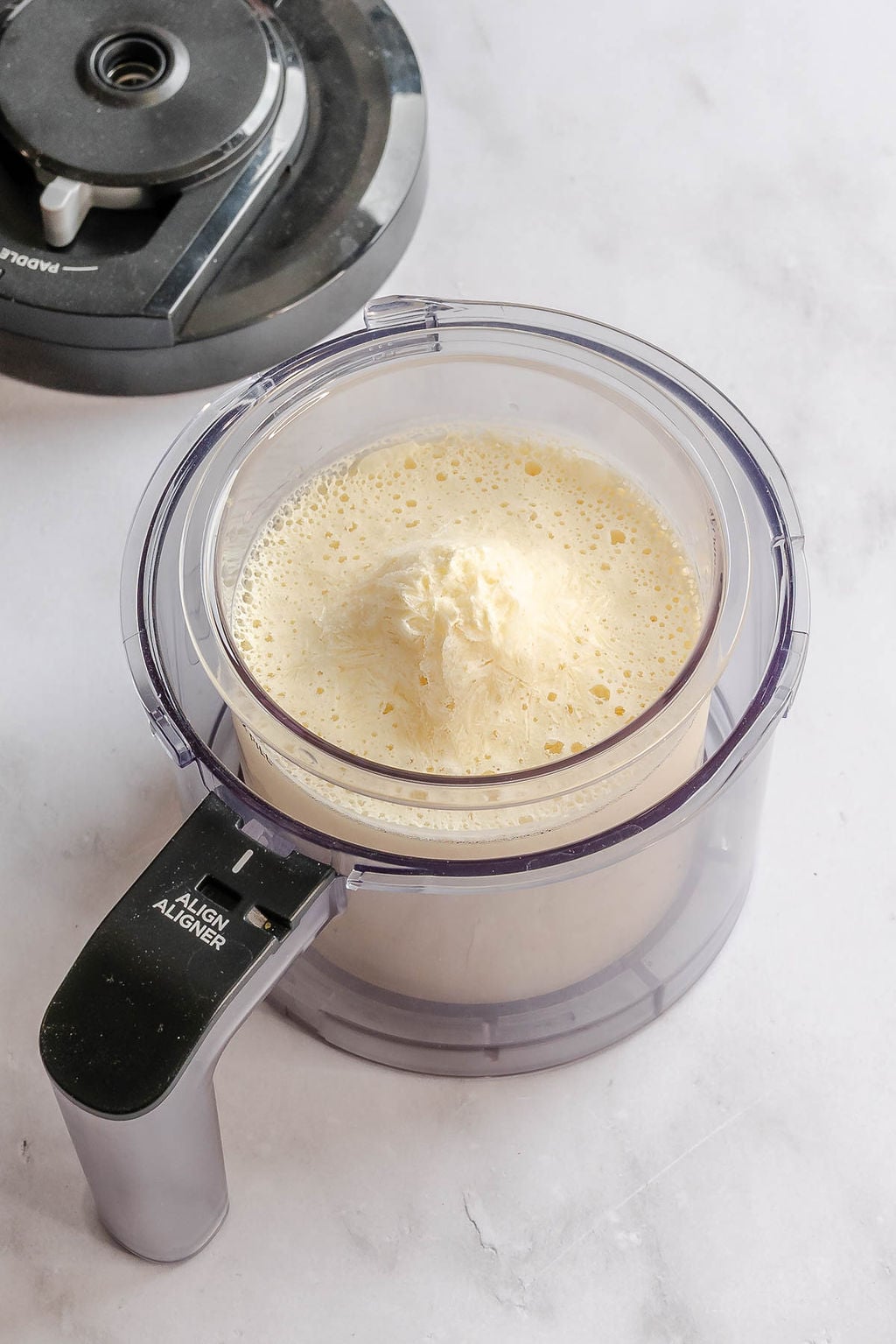 Process shot showing Ninja Creami Dole Whip in creami container.