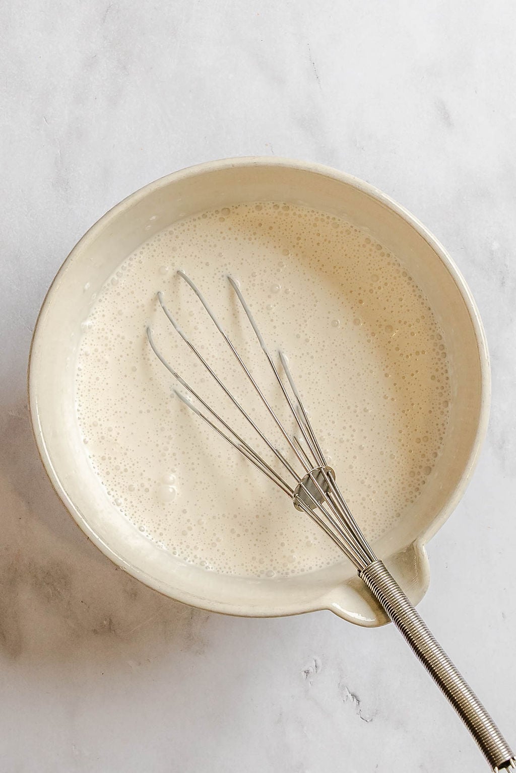 Process shot showing mixing ingredients together in a bowl.