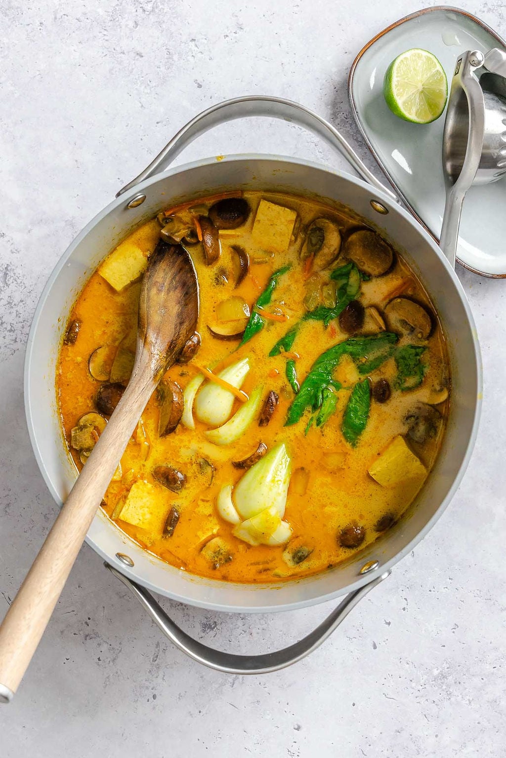 Process shot showing stirring Easy Vegan Laksa in a pot.