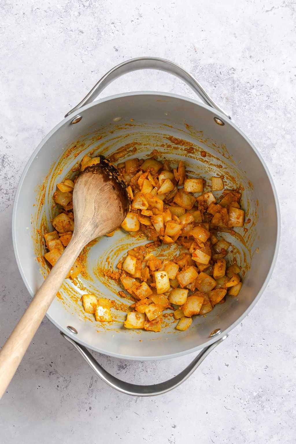Process shot showing stirring Easy Vegan Laksa ingredients in a pot.