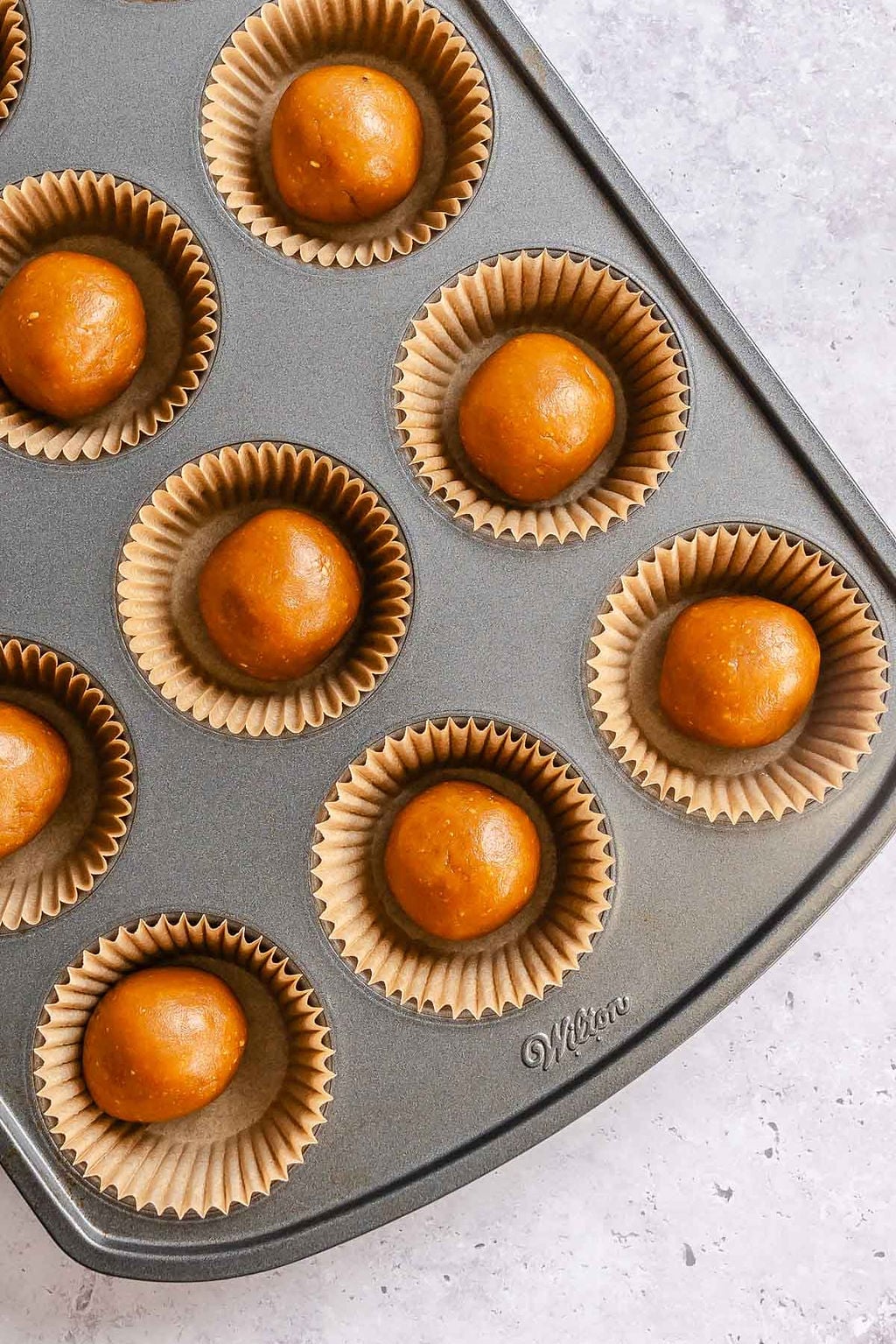 Process shot showing batter added to muffin tin.
