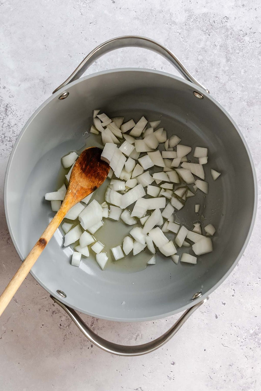 Process shot showing cooking onions in a pot.