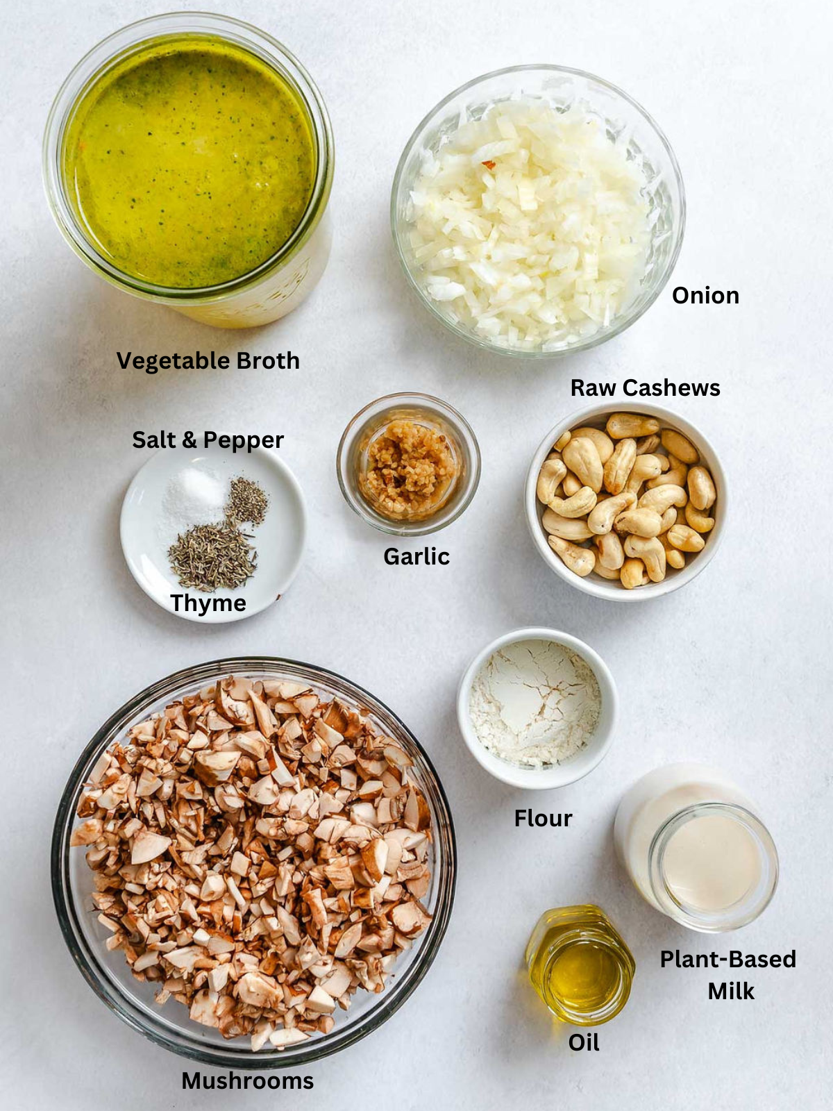 Ingredients for Homemade Vegan Condensed Cream of Mushroom Soup measured out on a white surface.